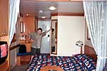 View of Bed and Hallway Bathroom - Cat. 4 Stateroom on the Disney Magic